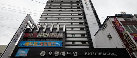 A multi-story building with a prominent sign for Hotel Head-One.