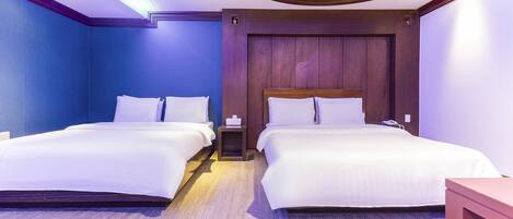 Habitación de hotel con dos camas, cabeceros de madera y un diseño moderno en el techo.