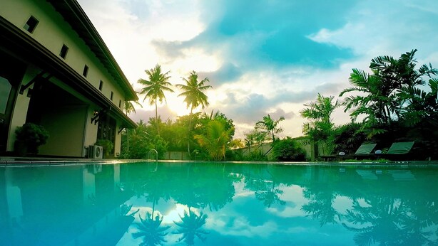 Una piscina con vistas despejadas a la arquitectura circundante y palmeras.