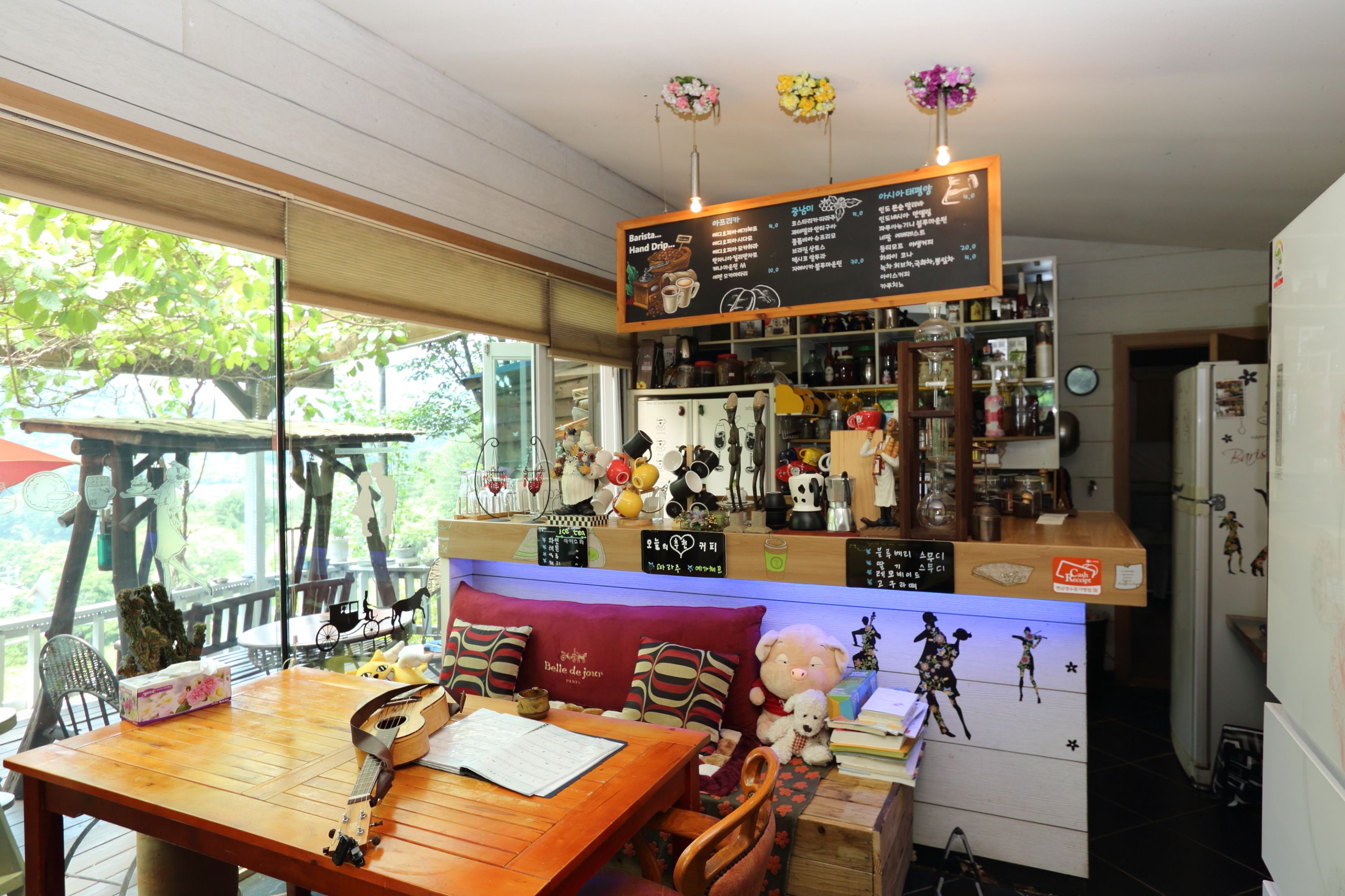 A cozy café with a wooden table, a cushioned bench, and a menu board.