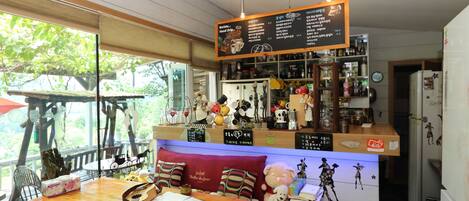 A cozy café with a wooden table, a cushioned bench, and a menu board.