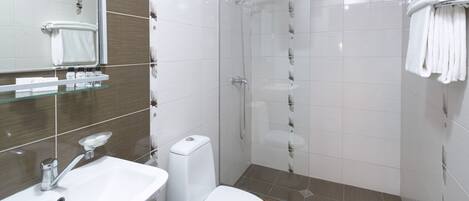A modern bathroom with a sink, toilet, and glass shower enclosure.
