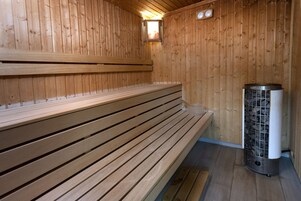 Een houten sauna met banken en een centrale verwarming.