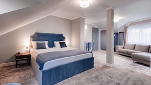A modern bedroom with a large bed, a desk, and a sofa. - Hotel Meridian (Cluj-Napoca)