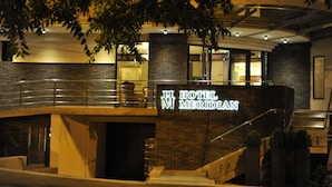 The exterior of Hotel Meridian with a prominent entrance, a brick facade, and a staircase leading to the entrance. - Hotel Meridian (Cluj-Napoca)