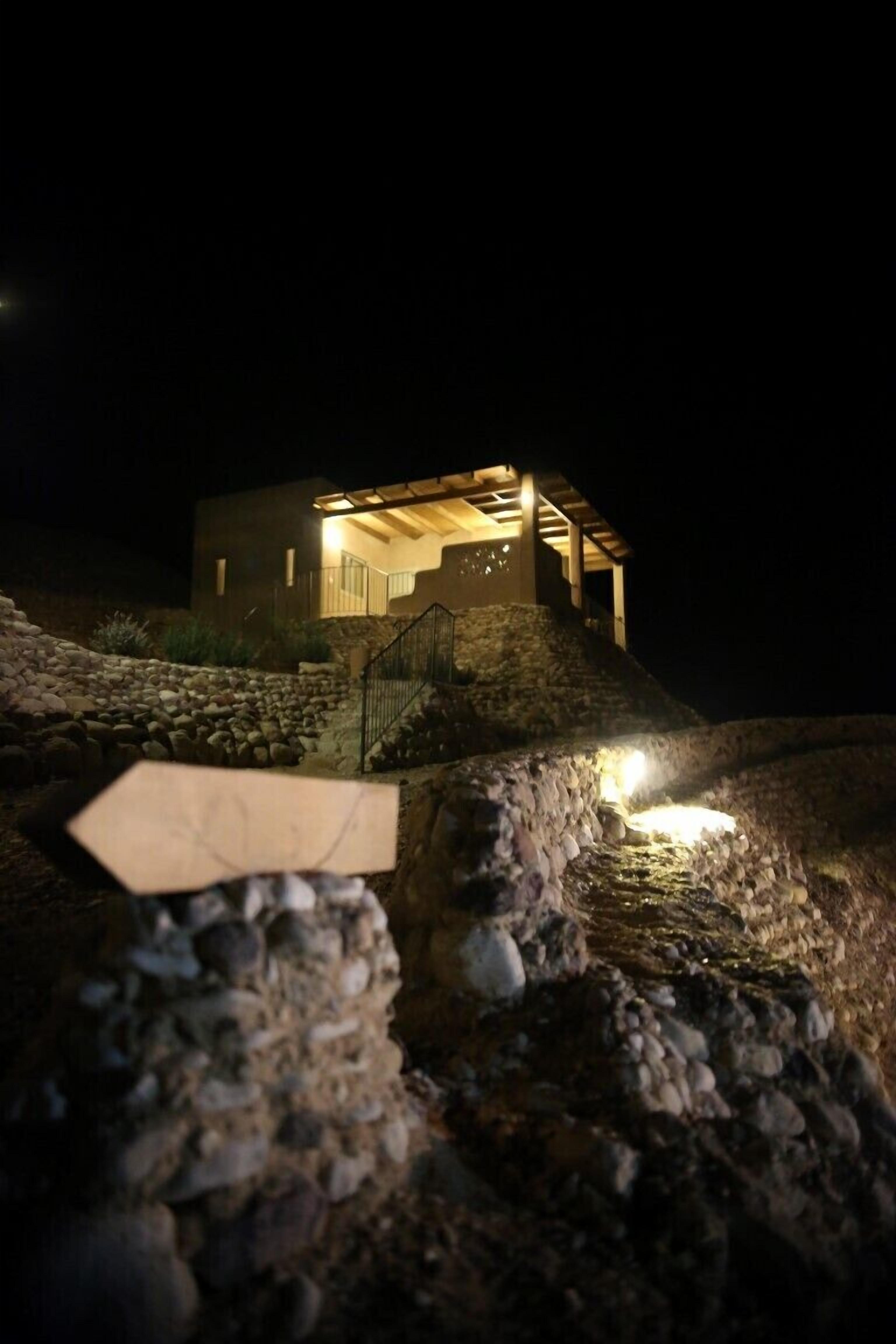 Una casa con una escalera de piedra que sube a una terraza de madera.