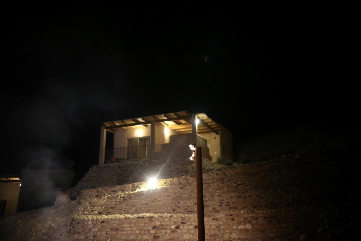 A building with a stone exterior and a lit entrance at night.