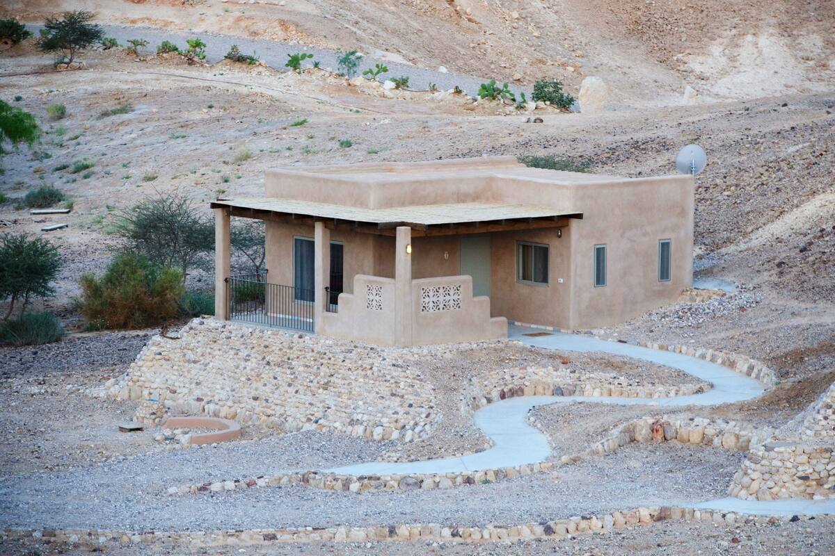 Un bâtiment de style désertique, doté d’un toit plat, d’un petit porche et d’une antenne parabolique.