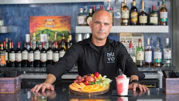 A bar with a variety of liquor bottles and a fruit platter on the counter.