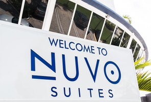 «NUVO SUITES» -kyltti, josta näkyy selkeästi sisäänkäynti ja taustalla parkkialue.