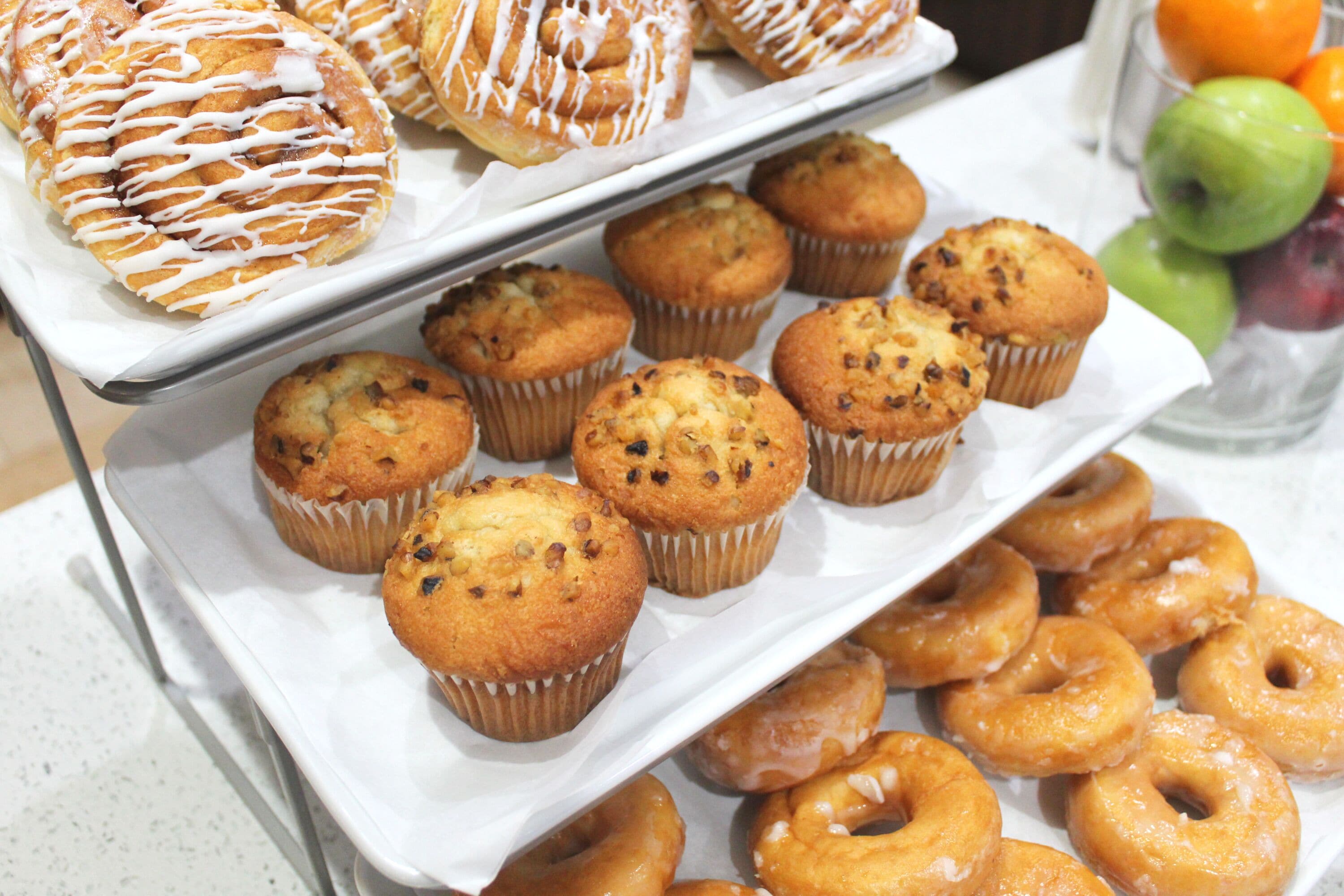 Una bandeja de muffins y donas sobre una mesa.