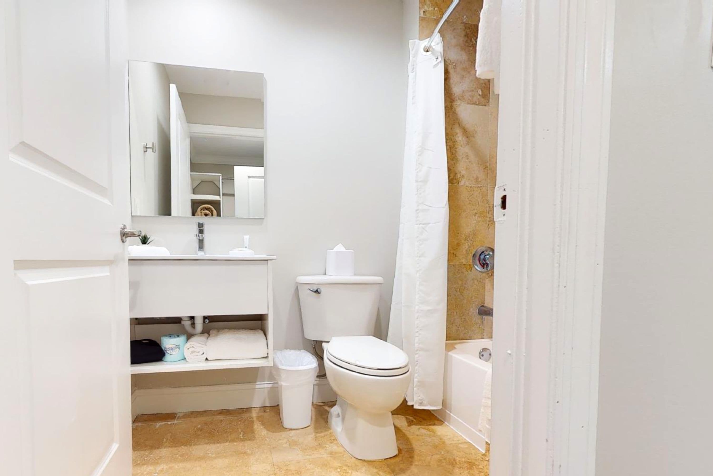 Ein Badezimmer mit Toilette, Waschbecken und Spiegel.