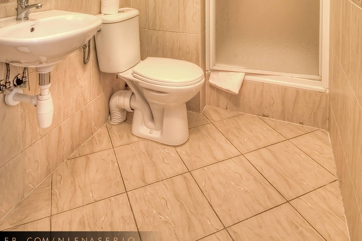 A bathroom with a sink, toilet, and shower.