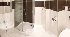 A modern bathroom with a glass-enclosed shower, a sink, and a toilet.