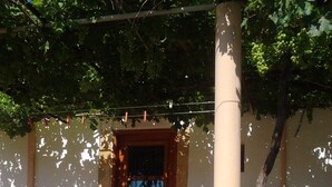 Un monument de pierre dans un jardin, avec un bâtiment en arrière-plan.