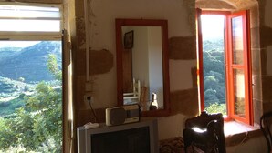 Une pièce avec une télévision, un miroir et une fenêtre dotée d’un cadre rouge.