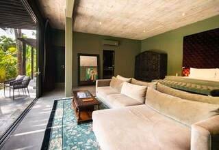 A modern living room with a beige sectional sofa, a wooden coffee table, and a patterned rug.