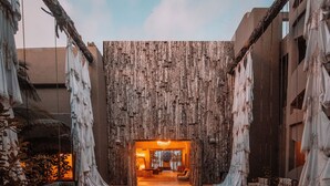 A spacious entrance with a wooden wall and hanging fabric. - Casa Malca (Tulum)