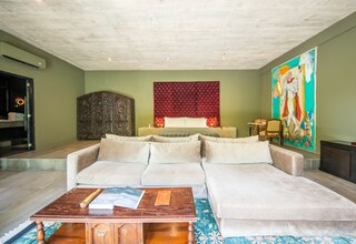A living room with a large sofa, a coffee table, and a red accent wall.