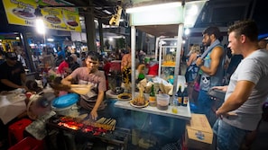 A busy street food stall with a grill and cooking utensils. - Holiday Inn Express Jakarta Wahid Hasyim by IHG (Jakarta)