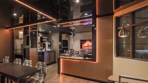 A modern restaurant with a wooden interior, a buffet counter, and a television displaying a fire. - Hôtel Le Chablis (Montreal)