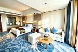 A hotel room with a bed, a sofa, a coffee table, and a large mirror. - GRAND METROPARK GAOMI (Weifang)