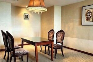 A conference room with a rectangular table and four upholstered chairs. - GRAND METROPARK GAOMI (Weifang)
