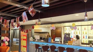 A bar area with stools, a counter, and a bartender.