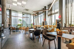 A modern dining area with large windows, high ceilings, and contemporary furniture.