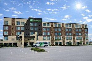 A Holiday Inn hotel with a modern design, featuring multiple floors and a parking lot. - Holiday Inn Chicago - Schaumburg by IHG (Schaumburg)