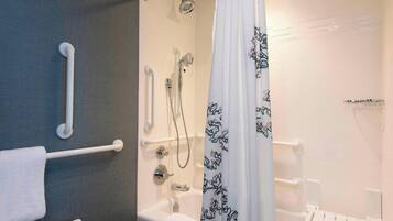A bathroom with a shower, toilet, and grab bars.