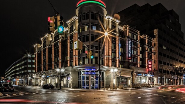 A hotel with a prominent circular sign on top, multiple floors, and a well-lit entrance. - Residence Inn Ann Arbor Downtown (Ann Arbor)