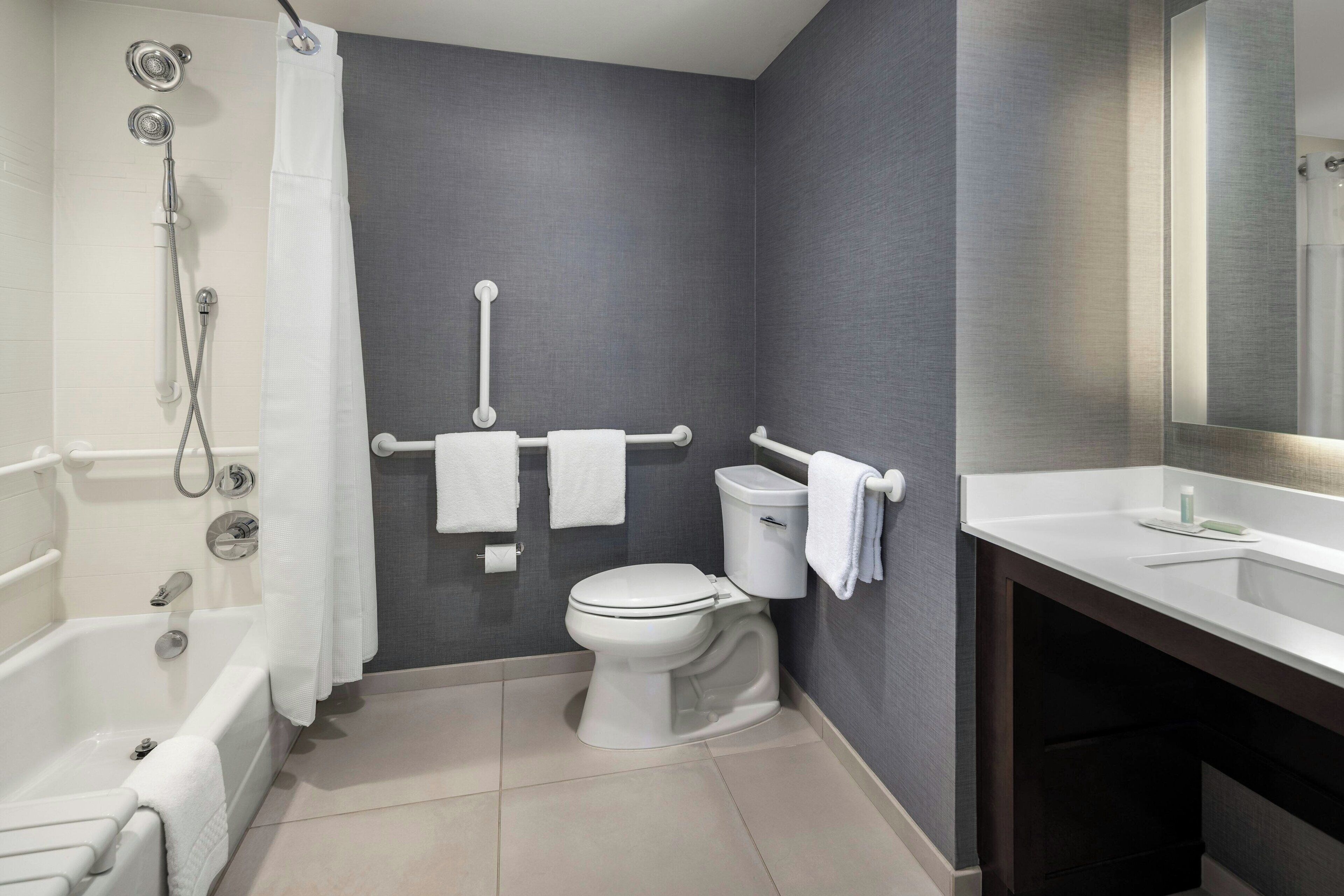 A modern bathroom with a bathtub, toilet, and sink.