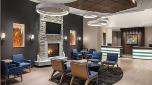 A modern lobby with a stone fireplace, blue seating, and a reception desk. - Residence Inn Ann Arbor Downtown (Ann Arbor)
