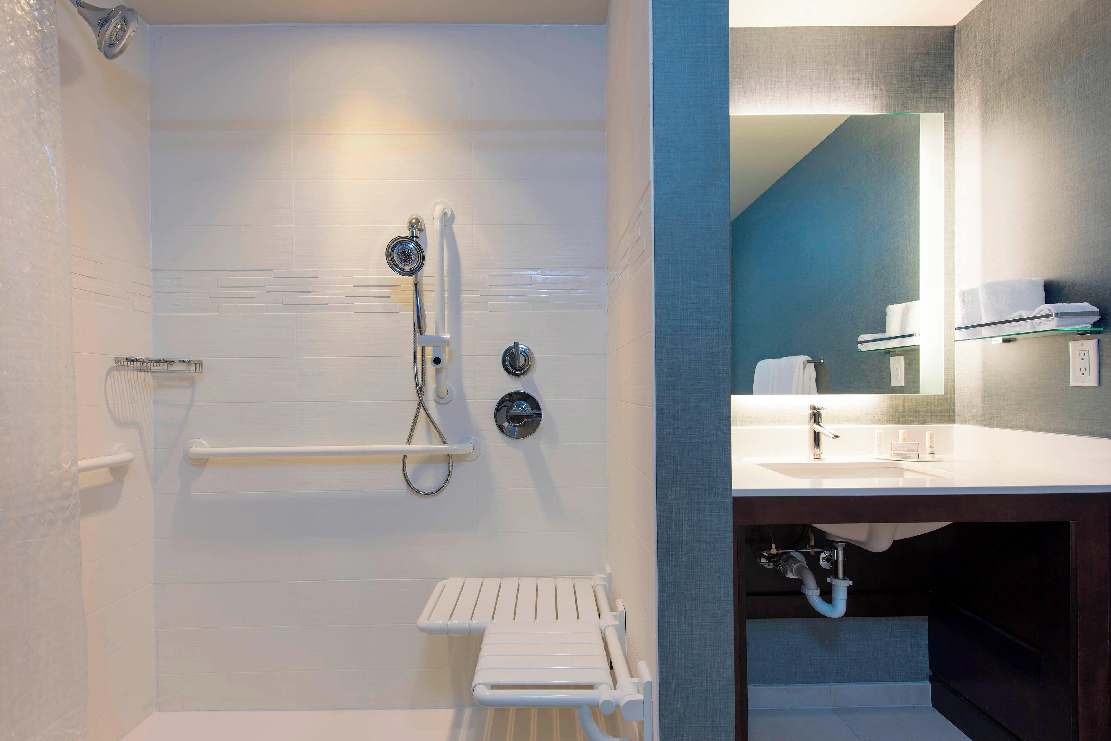 A modern bathroom with a shower, a toilet, and a sink.