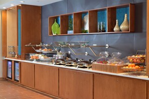 A buffet setup with various food items and a beverage dispenser.