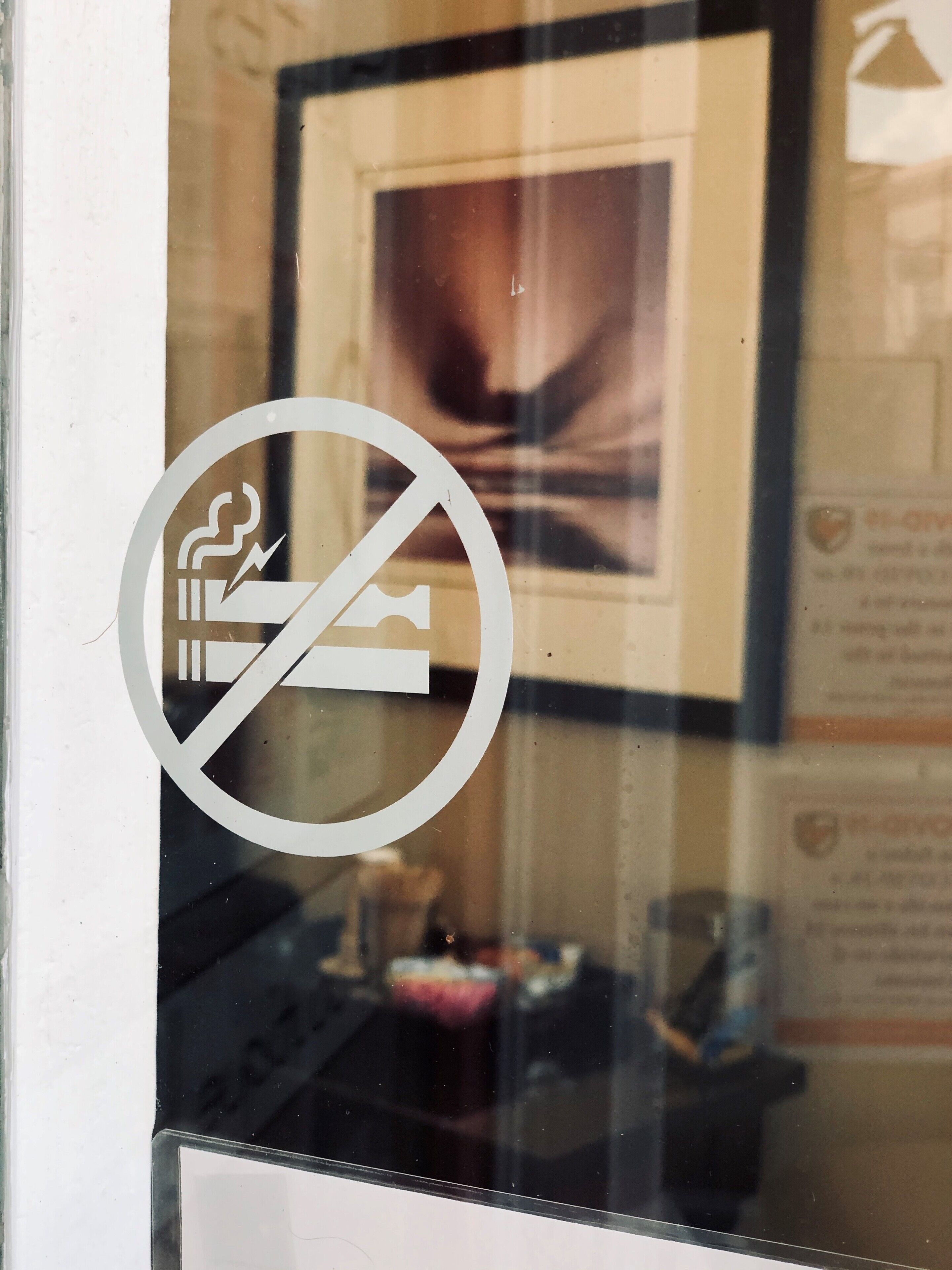 A no-smoking sign on a glass window.