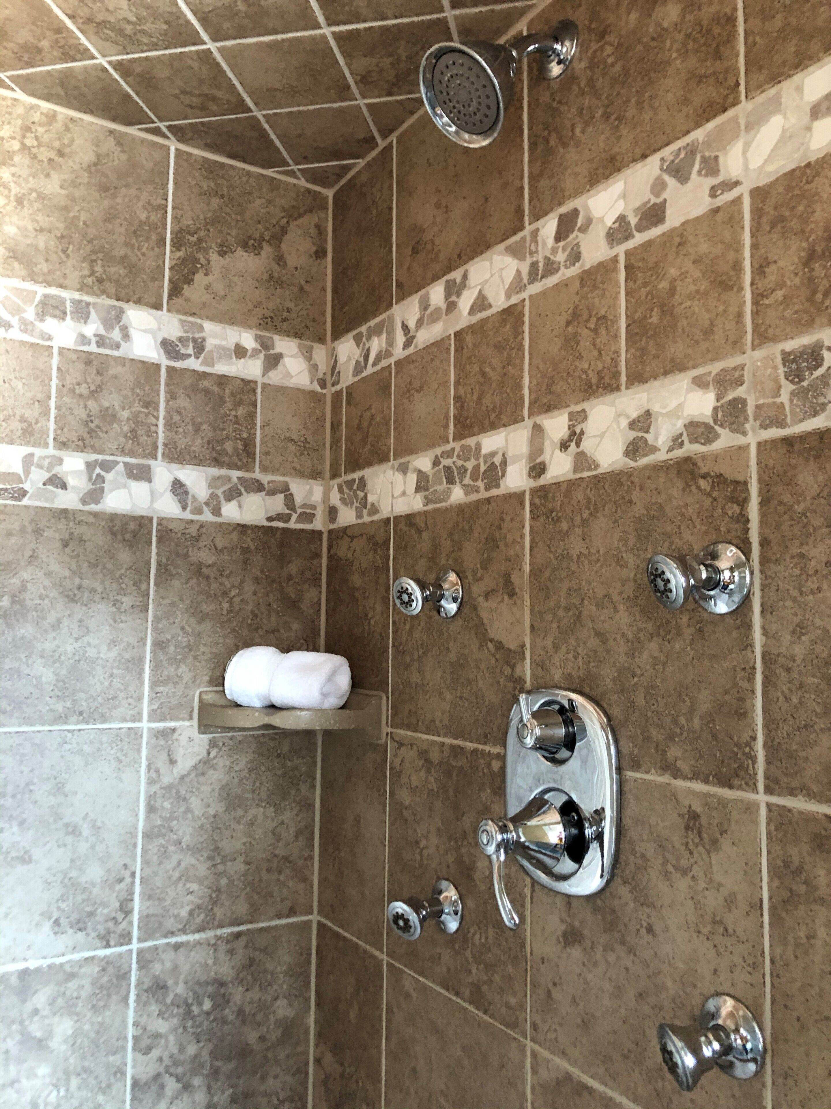 A bathroom with a shower, a towel rack, and a sink.