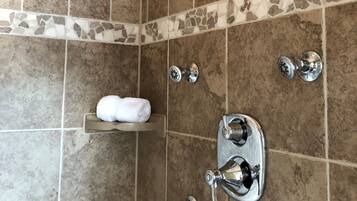 A bathroom with a shower, a towel rack, and a sink.