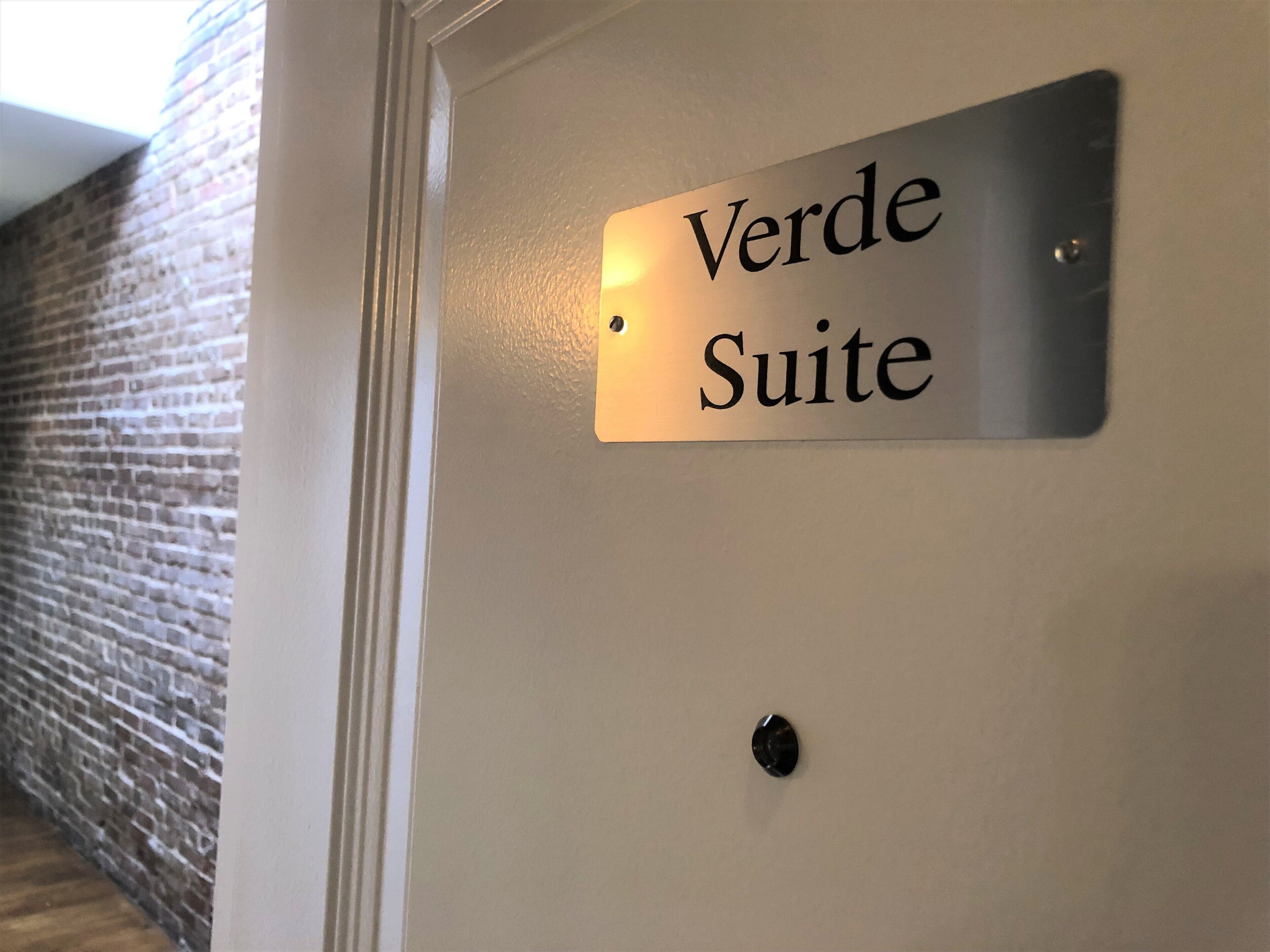 A sign reading "Verde Suite" on a wall.