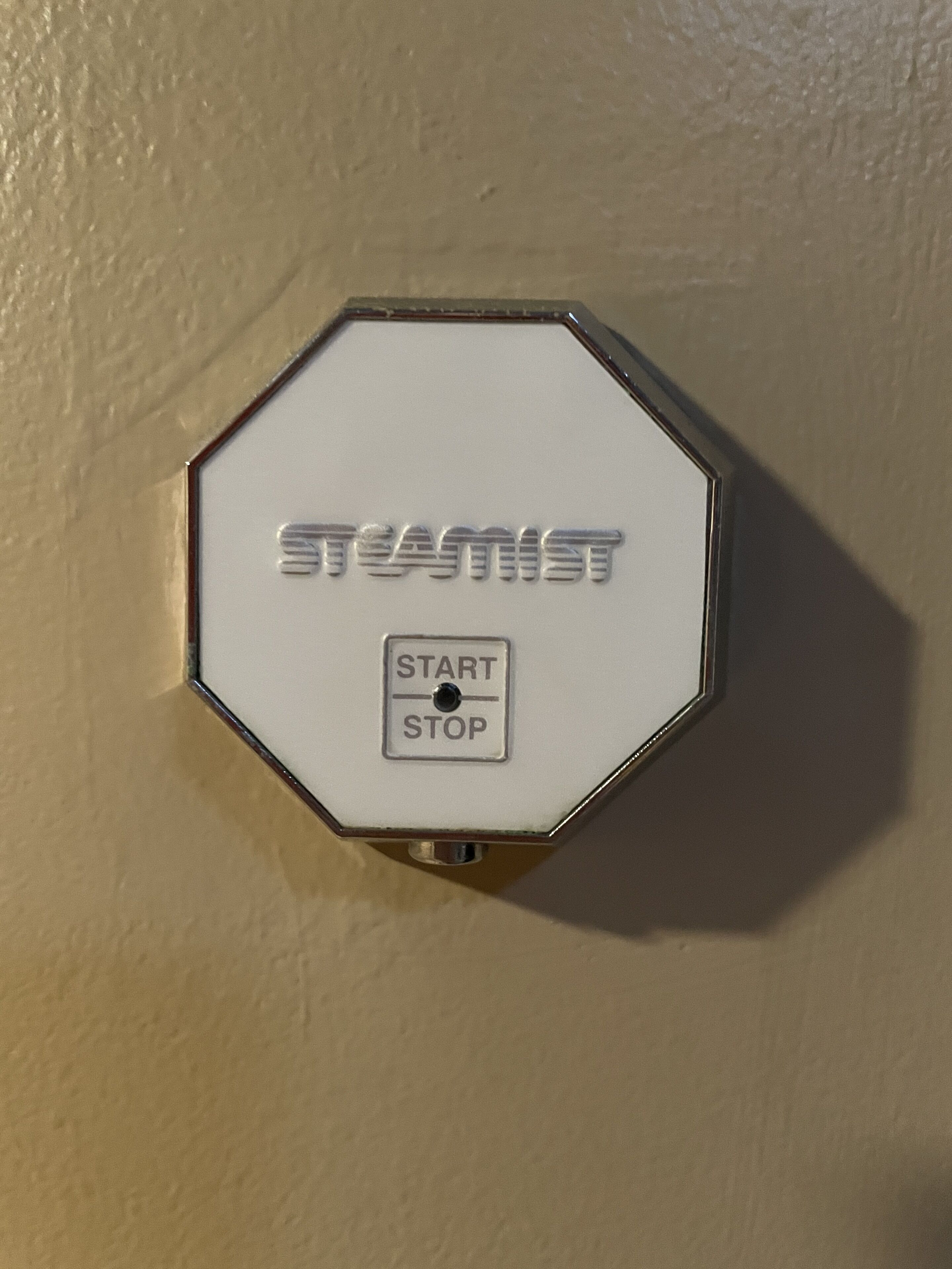 Eine an der Wand befestigte Vorrichtung mit dem Markennamen „TEASTIST“ und einer „START STOP“-Taste.
