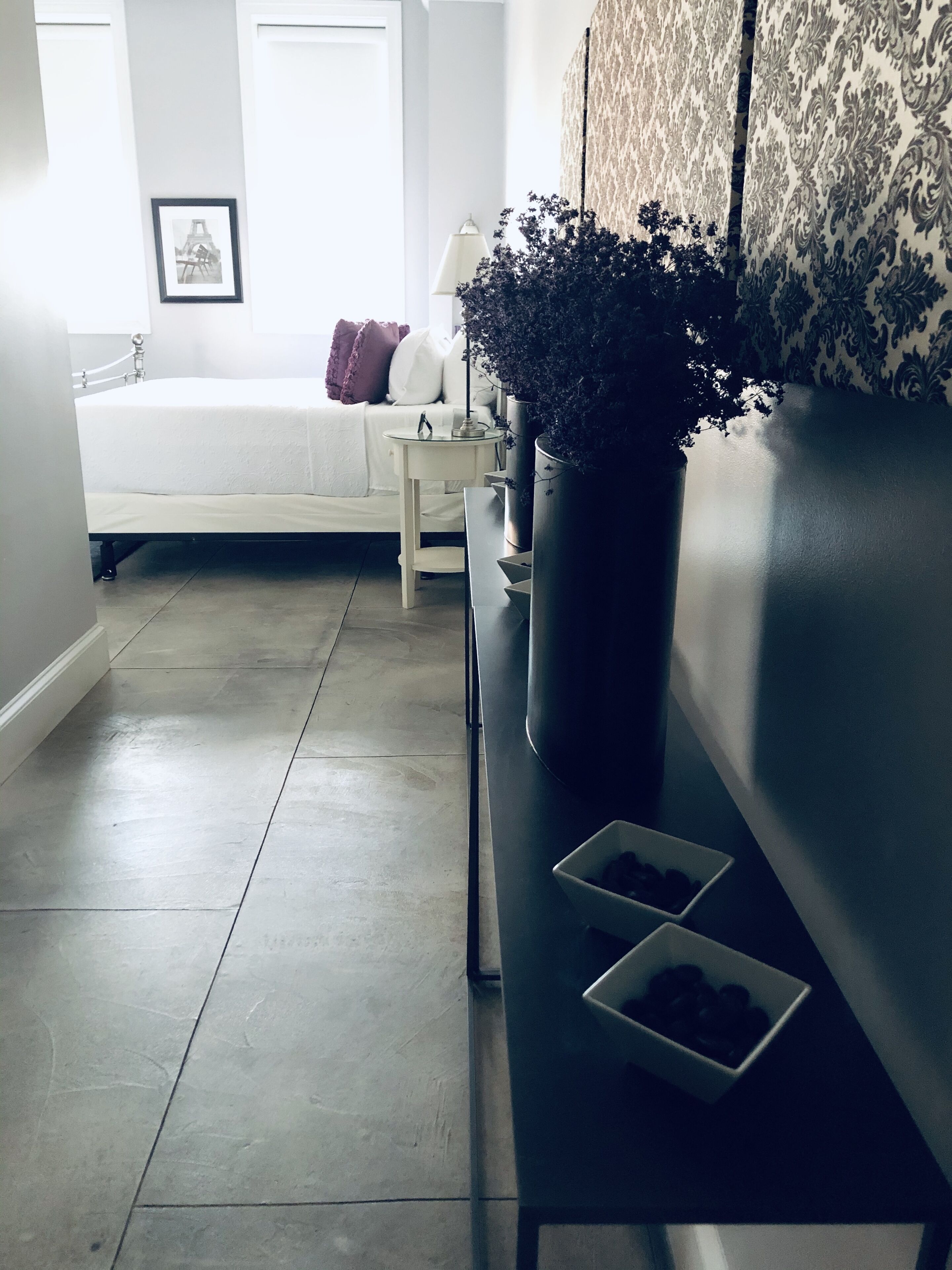 Une chambre à coucher moderne avec un lit, une table de chevet et une plante en pot.