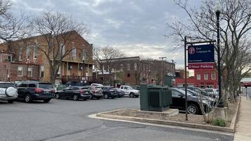 A parking lot with multiple cars, a sign indicating East Culpeper St, and brick buildings in the background.
