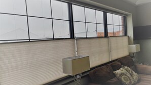 Una sala de estar moderna con un ventanal grande, un sofá, una mesa de centro y una lámpara.