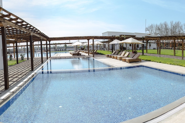 Una piscina al aire libre, sillones reclinables de piscina