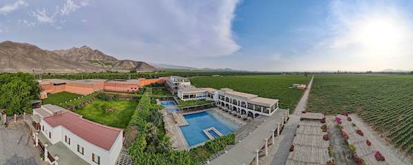 A resort with a swimming pool, guest rooms, and a view of the mountains.