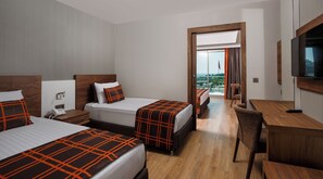 Une chambre d’hôtel avec deux lits, un bureau, une chaise, une télévision et un balcon avec vue.