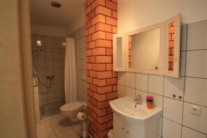 Un baño con ducha, inodoro y lavabo.