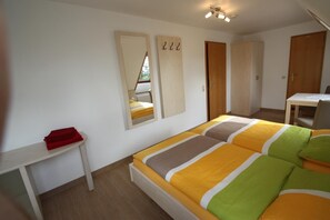 Un dormitorio con cama, escritorio y armario.