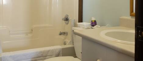 A bathroom with a bathtub, toilet, and sink.
